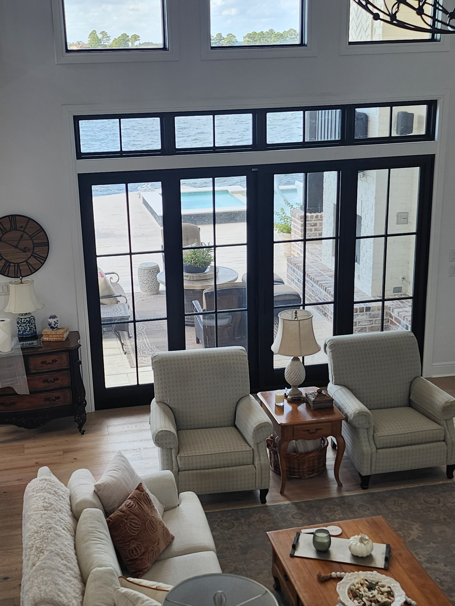Space City Window Tinting installer on ladder applying film to waterfront home windows with lake view